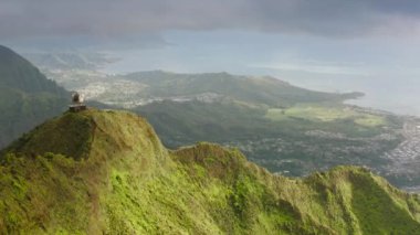 Oahu Adası, Hawaii 'deki Cennet Merdivenleri' nin dramatik manzarası. Haiku merdivenlerinin üstündeki hava manzarası. Oahu adasında turistik bir yer. Dik yamaçlı destansı yeşil dağ zirveleri, dikey eğim 4K