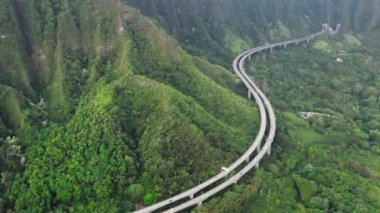 Güzel Hawaii doğası. Dik yeşil dağdaki tünelden tünele giden hava manzaralı arabalar. Eyaletler arası H3 otoyolu Amerika 'nın en pahalı otoyolu. 4K manzaralı Oahu adasının ana yolu.