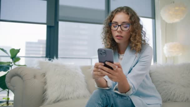 Hermosa Mujer Sentada Sofá Utilizando Teléfono Inteligente Interior Del Apartamento — Vídeos de Stock