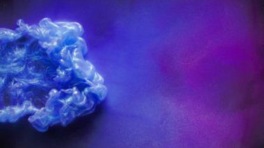 Mavi mürekkebin suda çözünmesinin yavaş çekim etkisi. Soyut renkli arkaplan. Mor renkli mavi mürekkep bulutu. Sihirli yaratıcı duvar kağıdı. Suyun altında renklerin sıçraması, 4k görüntü