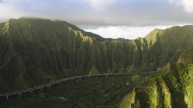 Gün doğumunda orman doğa manzaralı ünlü dağ yolu. Ulaşım geçmişi olan manzara havası, yaz gezisi 4K. Hawaii adası Oahu tarafından işletilen H-3 otobanındaki destansı manzara