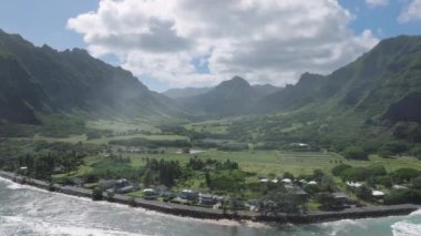 Sinematik Kualoa Çiftlik Parkı, Oahu Adası, ABD. İnsansız hava aracı Hawaii doğası boyunca uçuyor. Manzaralı dağları olan yeşil tropik bir ada. Yaz tatili, egzotik seyahat beldesi