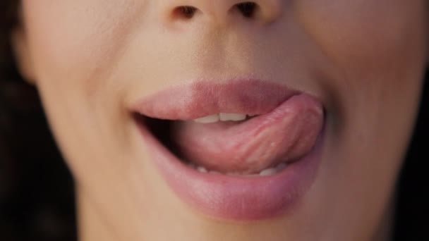 性感女人舔丰满的嘴唇和性咬 紧贴着年轻女人的脸 用完美的草皮咬性感的粉红嘴唇 用舌头舔 迷人的女人嘴唇上的毛被风吹散了 — 图库视频影像