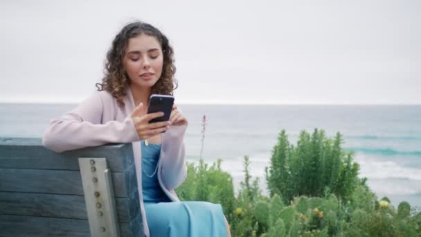 Młoda Kobieta Używająca Smartfona Zewnątrz Śliczna Kręcona Dziewczyna Patrzy Telefon — Wideo stockowe