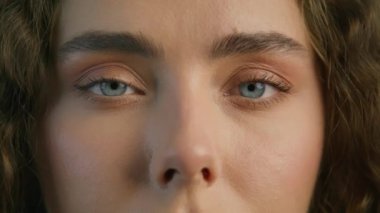 Macro shot of light green eyes of young beautiful woman. Slow motion light blue eyeball iris. Good vision, I see you. The eye is the mirror to ones soul concept. Fashion girl looking at RED camera 4K