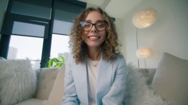 Genç akıllı kadının portresi video konferansa katılan webcam ile konuşuyor. İnternet bağlantısını kullanarak müşterilerle pazarlık eden bir kız. Video çağrısı, uzaktan çalışma veya konsept 4K
