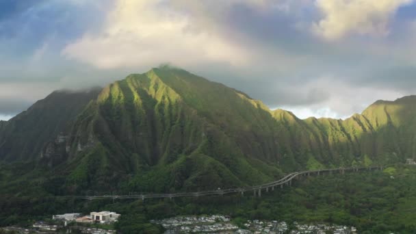 4Kハワイの自然を望むシネマティックロードの航空機 急な緑の山のトンネルまで道路で運転するドローンビューカー トンネルオアフ島に向かう息をのむ州間高速道路H3 — ストック動画