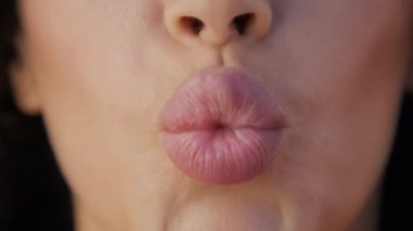 Kadın dudaklarının hava öpücüğü gönderirken yakın plan çekimi. Güzel pembe dudaklar kozmetoloji için mükemmel arka plan, plastik cerrahi, hyaluronik asit enjeksiyonu, dudak büyütme prosedürü, güzellik enjeksiyonları