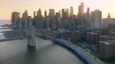 Küresel ekonomi, ticaret piyasası sermayesi, banka işletmeleri finans kavramı. Brooklyn Köprüsü 'ndeki helikopter görüntüsü New York City, ABD 4K. Liman kenarındaki yüksek ofis binaları. Manhattan şehir trafiği NYC