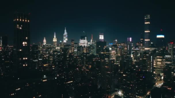 ニューヨーク市のダウンタウンの夜間フライトで照らされた航空機 シネマティックな空中パノラマNycビルはダウンタウンの夜のスカイラインを建てます 未来のメガポリス都市東海岸 アメリカの都市旅行コンセプトの背景 — ストック動画