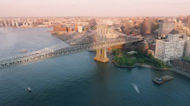 Manhattan Köprüsü sinematik mimari görüşü. Brooklyn şehir manzaralı East River 'ın yukarısında çekim yapıyoruz. AERİAL uçuşu altın günbatımı ışığında ünlü sanayi köprüsüne doğru