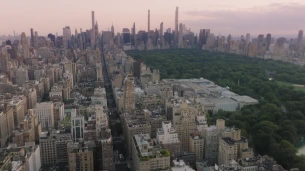 マンハッタンの高層ビルは緑豊かな都市セントラルパークにあります 緑の公園や建物に囲まれた美しい湖 シネマティック セントラル パークの風景パノラマ ニューヨークのダウンタウン映像 — ストック動画