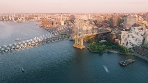 マンハッタン橋 コンクリート建築 映画の景色 ブルックリン市街の景色を望む東の川の上を撮影 ゴールデンサンセットライトの有名な工業橋に向かうエレアルフライト — ストック動画