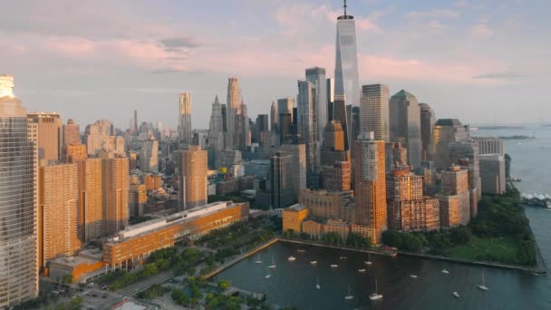 モーションバックグラウンドの風光明媚なモダンな高層ビルとピンクの雲を持つニューヨークのエピック航空 ロックフェラー パークUsa ゴールデンサンセットの下のマンハッタンの金融地区の息をのむようなパノラマ — ストック動画