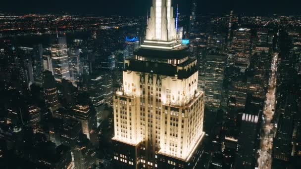 帝国大厦顶部的观景台周围的景色闪烁着光芒 美国4K背景下城市灯光下的标志性曼哈顿摩天大楼的史诗式空中拍摄 — 图库视频影像