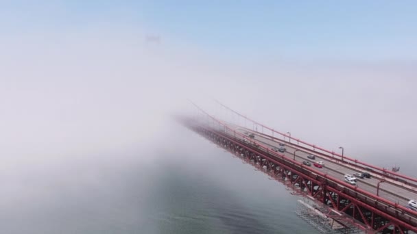 美国加州西海岸旧金山的红色金门大桥的空中景观 4K段风景画卡尔覆盖太平洋上方繁忙道路的雾 汽车飞速驶入浓雾中 — 图库视频影像