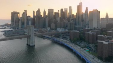 Günbatımı ışığı ve New York 'taki modern iş alanının üzerindeki altın bulutlar üzerinde sinematik bir manzara. 4K modern cam binaların mimarisi Amerikan şehir manzaralı. İş ofisleri