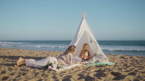 Młoda Matka Leżąca Kocu Białym Namiocie Płóciennym Plaży Bawiąca Się — Wideo stockowe