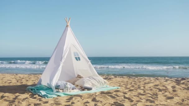 蓝色天空中的信息背景 浪漫的夜晚 建立在沙滩上 夏日的夕阳西下 沙滩上蔚蓝的天空 蓝色的海浪慢动作 浪漫的约会设置与白色帆布帐篷4K — 图库视频影像