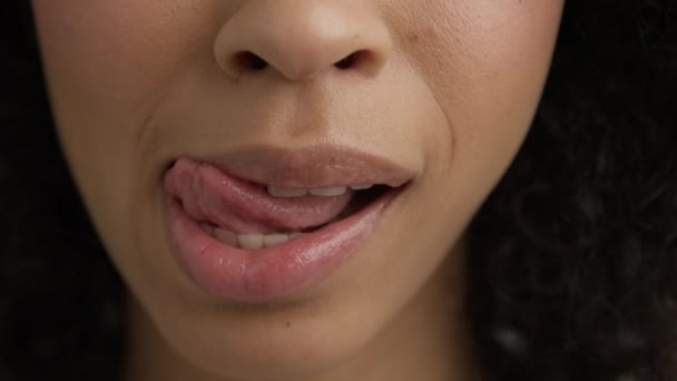 センセーショナルな女性は プランプの唇を舐め 微笑みます 完璧な柔らかい肌とセクシーなピンクの唇 舌で舐める若い女性の顔を閉じます 若い女性の唇の背景 正確に顔の周りに髪を浮かべる — ストック動画