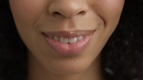 暗い肌で幸せな笑顔の女性を閉じます 完全に美しいピンクの唇を持つ多民族の少女 自然な白い歯を持つ美しい女性の唇 デンタルコンセプトの背景 エキサイティングな感情 — ストック動画