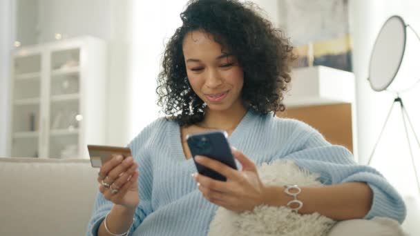 Smilende Multi Racistisk Kvinde Holder Smartphone Kreditkort Sidder Sofaen Moderne – Stock-video