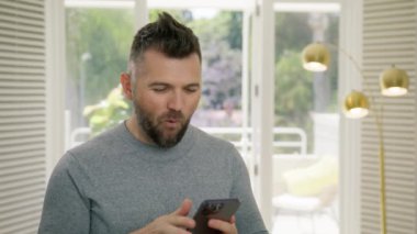 Şaşırdım yakışıklı erkek işadamı. Şaşırmış heyecanlı adamın portresi akıllı telefondan mesajları kontrol ediyor. Cep telefonlu mutlu adam çevrimiçi kazanıyor, iş buluyor, başarı konsepti 4K