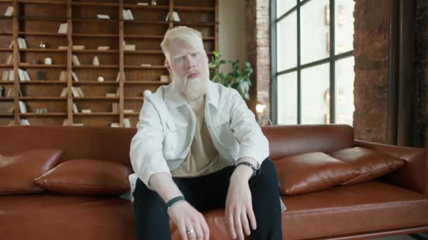 Pria Albino Menyedihkan Duduk Sofa Kulit Interior Apartemen Pria Serius — Stok Video