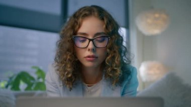 Not alan üniversite öğrencisinin portresi, modern daire 4K 'de kapalı alanda ders çalışan Webinar ya da sanal eğitim sınıfını izliyor. Gözlüklü zarif bir kadın dizüstü bilgisayar kullanarak internette öğreniyor.