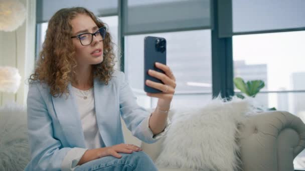 若い女性は 携帯電話を話すことに同意することを明確にします セルガジェット上のモバイルフロントカメラを使用してビデオチャットで話す若い起業家 20代の女性マネージャーフレンドリーでハッピーな返信コミュニケーション — ストック動画