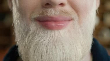 Sarı sakallı, gülümseyen yakışıklı adama yaklaş. Gelişigüzel pozitif albino erkek çeşitliliği. Hollywood gülümseme kavramı, beyaz düz dişler, gülümseyen dudaklar. Duygusal Eğlence, Neşe Yaşam Tarzı