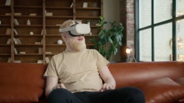 Süper heyecanlı bir adam modern 3D VR 'ı kullanarak bir şeye dokunuyor kapalı alanda Google' da AR gözlüğü kullanıyor. Gelişmiş gerçeklik deneyimi için sanal gerçeklik kulaklığı takan yakışıklı genç hippi.