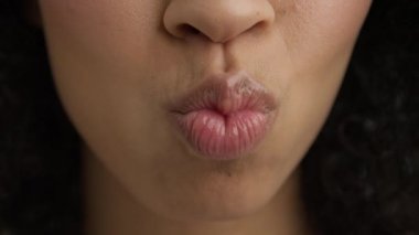 Kadın ağzı ağır çekimde. Mükemmel yumuşak ten seksi çok ırklı çeşitli model gülümseyen öpücük 4K. Dudaklar gün ışığında öpüşür. Koyu tenli, parlak pembe dudaklı, güzel, seksi bir kadın model..