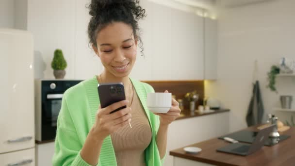 Diverso Modelo Rizado Mujer Bebiendo Café Celebración Teléfono Inteligente Haciendo — Vídeos de Stock