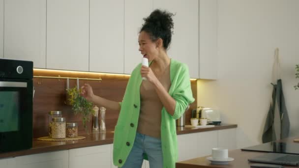 有趣的多种族女孩检查糕点 同时在电炉烘烤 现代家庭中漂亮家庭主妇的家务活 在厨房做饭的时候笑着 跳舞的女人 — 图库视频影像