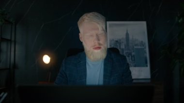 Gece geç saatlere kadar çalışan, bilgisayar ekranına bakan, çevrimiçi ticaret piyasasının dijital verilerini analiz etmeyi düşünen konsantre iş adamının portresi. Albino yavaş çekimde kapat