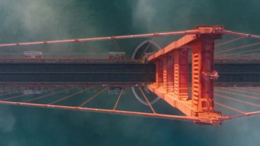 Golden Gate Köprüsü 'nün yukarıdan görünüşü, San Francisco, sisli altın gün batımı ışığı. Tepeden tırnağa mavi okyanus manzarası ve Kaliforniya 'nın ABD Golden Gate Köprüsü hava sahasının yüksek kırmızı yapısı.