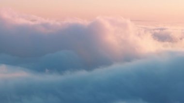 Arka planda gün batımında temiz hava sinemalarda nefes kesici. Cennet konsepti, doğa manzarası videosu. Havada dönen pastel rengi, pembe ve mavi kabarık bulutlar gökyüzünde 4K