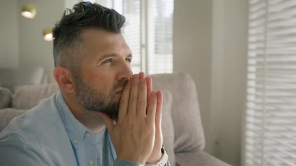 スタイリッシュなヘアドレスを持つ深刻な成熟したハンサムな男性は 問題を心配したり 自宅で心を集中させます 目を閉じた灰色の毛髪の男性は希望のコンセプトで祈りに手を入れる — ストック動画