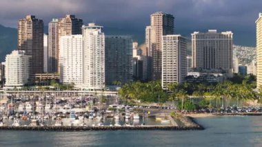 Havai 'de Waikiki Sahili sineması. Modern şehir arka planında fotokopi alanı olan bir yaz günü. Prestijli konut okyanus manzaralı sahil manzaralı ABD mülkü. Modern binalar Emlak iş insansız hava aracı 4K