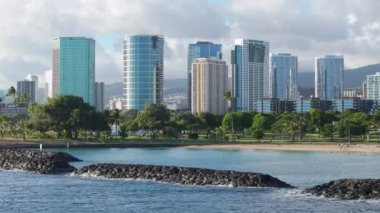 Prestijli konut okyanus manzaralı sahil manzaralı ABD mülkü. Modern binalar. Sinematik Honolulu Sahili, Hawaii. Modern şehir arka planında fotokopi alanı olan bir yaz günü. Gayrimenkul şirketi İHA 4K