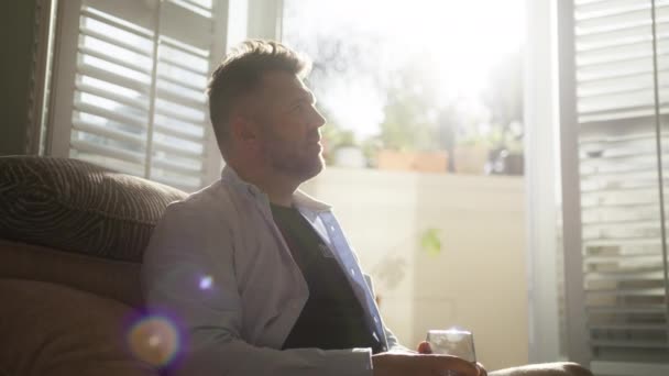 Kypsä Mies Istuu Avoimella Parvekkeella Valaistu Kultainen Auringonpaiste Linssi Soihtu — kuvapankkivideo