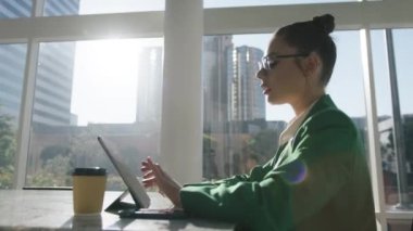 Modaya uygun bir iş kadını yönetici şehir planında Pad Teknoloji Cihazı 'na yazı yazıyor. İş yerinde dijital tablet kullanan yeşil takım elbiseli zarif profesyonel bir iş kadını.