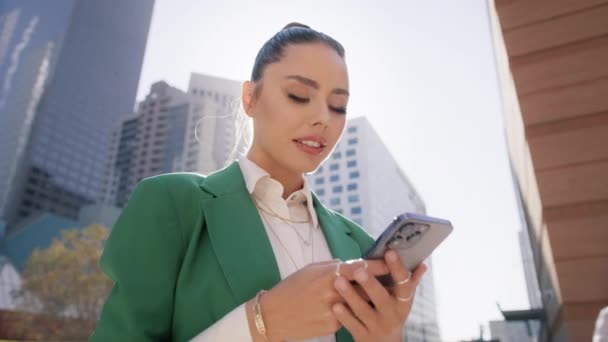 相当专业的女业务主管拿着手机站在城市街道背景的现代技术 漂亮的女商人在外面用智能手机 — 图库视频影像
