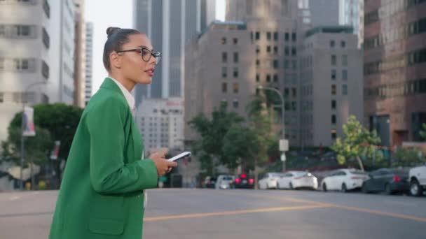 在市中心的城市街道上 身穿西服的白人女商人使用智能手机 戴着眼镜片的时髦漂亮女士看上去很成功 使用设备4K在网上浏览时尚杂志 — 图库视频影像