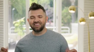 Merkez ofisteki genç ve mutlu profesyonel. Şık saç stili olan girişimci aptalca hareket ediyor ve dans ediyor. Yakışıklı adam kameraya bakıp gülümsüyor. Komik erkek yüzünü buruştururken başarıyı kutluyor, piyango kazanıyor