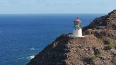 Dik kayalıklardaki deniz fenerinin tarihi binası mavi Pasifik Okyanusu 'nun üzerinde yükseliyor. ABD seyehat güzergahı 4K. Manzaralı Oahu Hawaii tropikal adası Makapuu Point Deniz feneri Amerika