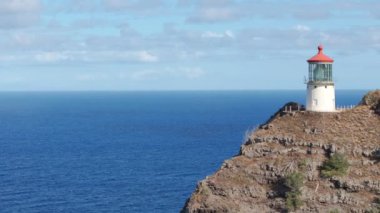 Mavi Pasifik Okyanusu 'nun üzerinde yükselen sarp kayalıklardaki deniz fenerinin eski tarihi havası. ABD seyehat güzergahı 4K. Oahu Hawaii tropikal adası Makapuu Point Deniz feneri