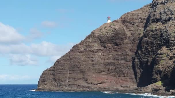 オアフ島のマカプーポイント灯台 青い太平洋の上に登る急な崖の上の灯台の古い歴史的建造物の風景的な航空機 米国の旅行先航空4K — ストック動画