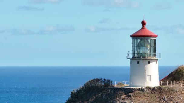 マカプーポイント灯台を閉じる 青い太平洋の上に登る急な崖の上の灯台の歴史的な建物の風景的な空撮 米国の旅行先航空4K オアフ島 ハワイの熱帯島 — ストック動画